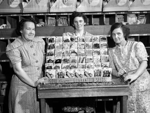 Three women with typical display rack of Burpee seeds, W. Atlee Burpee Company, Philadelphia, Pennsylvania, USA, Arthur S. Siegel, U.S. Farm Security Administration, April 1943