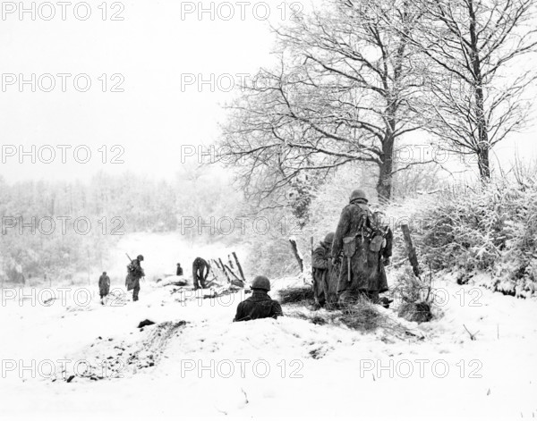 American Infantrymen of the 335th Regiment, 84th Division, taking positions in snow on the front, just past Amonines, Belgium, U.S. Army Signal Corps, January 4, 1945
