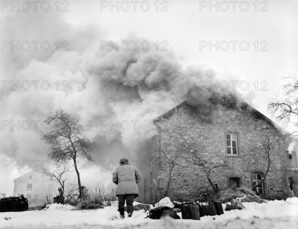 Burning home drew heavy barrage of enemy shellfire, near Lmore, Belgium, U.S. Army Signal Corps, January 16, 1945