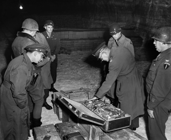 General Dwight D. Eisenhower, Supreme Allied Commander, and General Omar N. Bradley, CG, 12th Army Group, examine suitcase of silverware, part of German loot stored in Merkers salt mine, Germany, U.S. Army Signal Corps, April 12, 1945