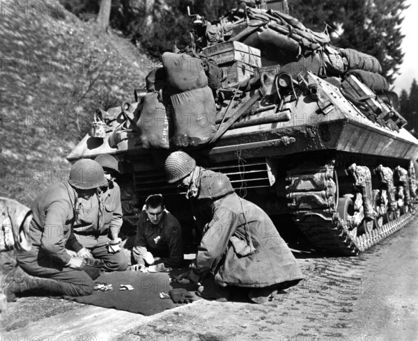 American tank destroyer crew, U.S. Third Army, 28th Division, shooting craps while awaiting removal of road block on road to Eisfeld, Germany, U.S. Army Signal Corps, April 12, 1945