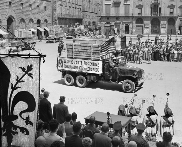Trucks returning priceless Florentine art treasure, which was taken to Bolsano by retreating Germans, passing reviewing stand of American, English and Italian officials, Piazzo Dei Signoria, Florence, Italy, U.S. Army Signal Corps, July 21, 1945