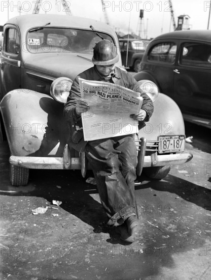 Factory worker reading newspaper while on break, Bethlehem-Fairfield shipyards, Baltimore, Maryland, USA, Arthur S. Siegel, U.S. Office of War Information, May 1943