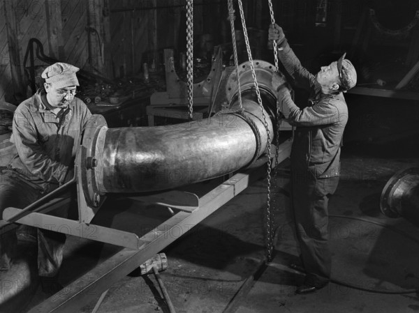 Two factory workers fitting flange on huge pipe, Bethlehem-Fairfield shipyards, Baltimore, Maryland, USA, Arthur S. Siegel, U.S. Office of War Information, May 1943