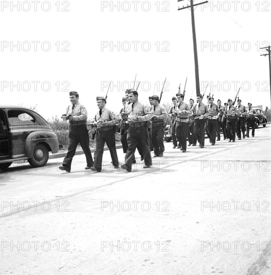 Home guard troops, with bared bayonets, carrying mess kits at Sojourner Truth Homes, a U.S. Federal Housing Project, during riot caused by white neighbors' attempting to prevent black tenants from moving in, Detroit, Michigan, USA, Arthur S. Siegel, U.S. Office of War Information, February 1942