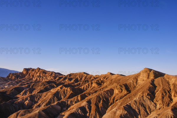 Hikers in distance along crest of Red Cathedral Trail near Zabriskie Point, Death Valley National Park, California, USA