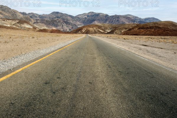 Asphalt road with mountains in background, diminishing perspective, Death Valley National Park, California, USA