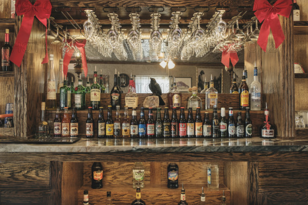 Saloon interior with rows of liquor and beer bottles on bar counter