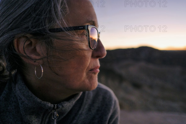 Head shoulders profile of senior adult woman looking at sunset, Zabriskie Point, Death Valley, California, USA