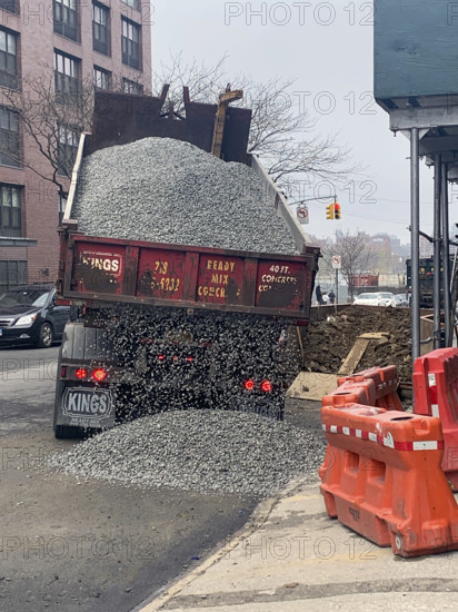 Dump truck delivering gravel on street, Brooklyn, New York, USA