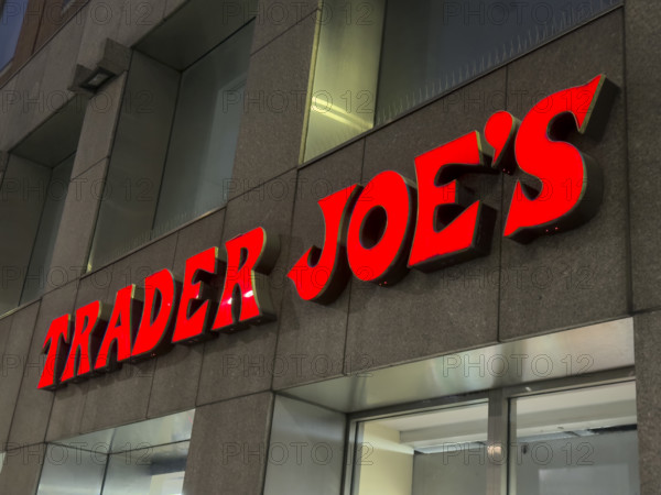 Trader Joe's grocery store, building exterior with company sign at night, New York City, New York, USA,