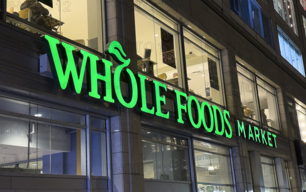 Whole Foods Market, building exterior with store sign at night, New York City, New York, USA