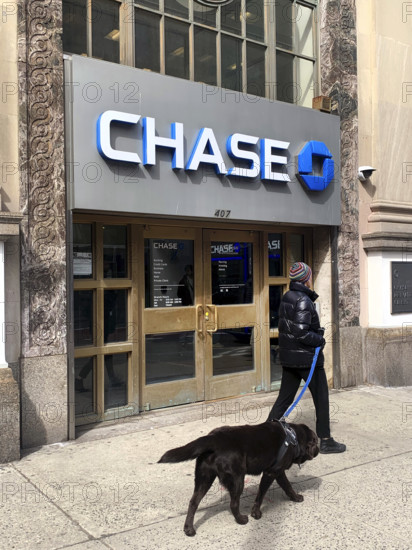 Chase Bank retail branch, building exterior and sidewalk scene with woman walking a dog, New York City, New York, USA