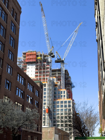 Construction cranes atop new residential building under construction, New York City, New York, USA