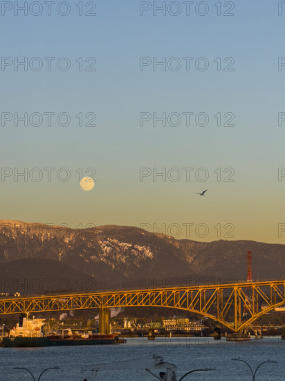 Full moon over Ironworkers Memorial Second Narrows Crossing, Burrard Inlet, and North Shore Mountains, North Vancouver, British Columbia, Canada