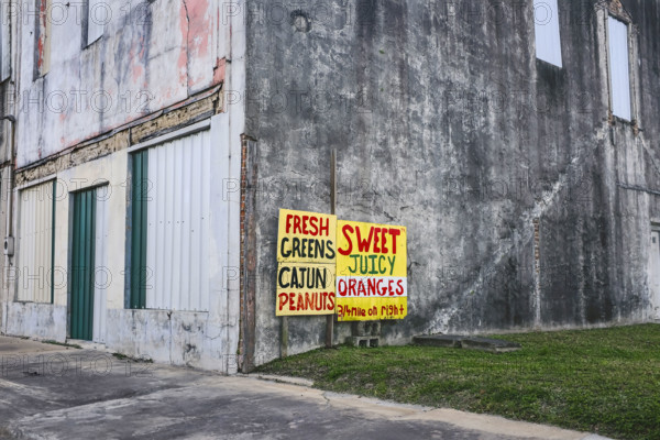 Sign advertising local farm stand on side of old building