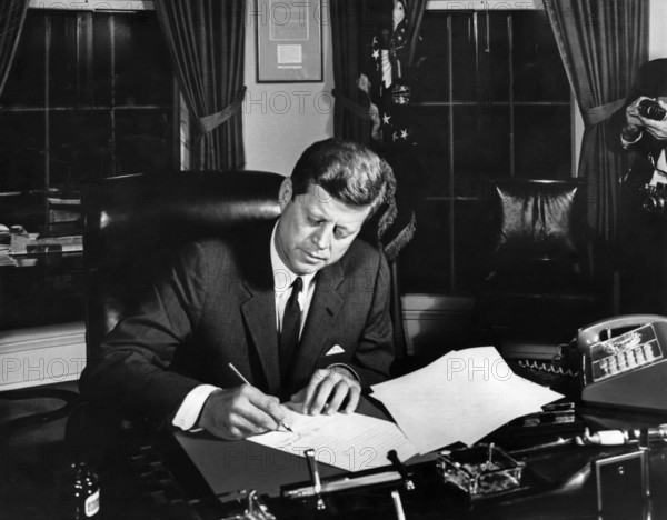 U.S. President John F. Kennedy signing the Interdiction of the Delivery of Offensive Weapons to Cuba during Cuban Missile Crisis, Oval Office, White House, Washington, D.C., USA, Cecil W. Stoughton, White House Photographs, October 23, 1962