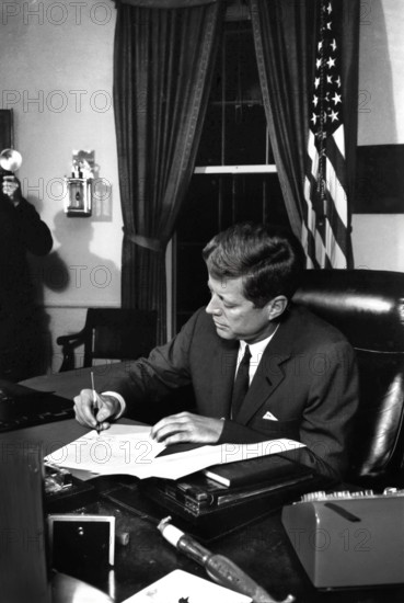 U.S. President John F. Kennedy signing the Interdiction of the Delivery of Offensive Weapons to Cuba during Cuban Missile Crisis, Oval Office, White House, Washington, D.C., USA, Cecil W. Stoughton, White House Photographs, October 23, 1962