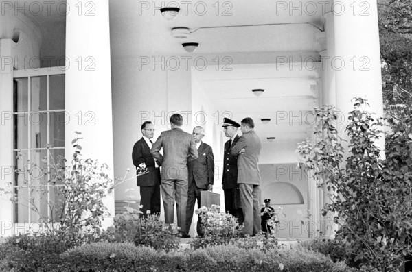 U.S. President John F. Kennedy (back view) speaking with (L-R) Special Assistant to the President for National Security McGeorge Bundy, Assistant Secretary of Defense for International Security Affairs Paul Nitze, Chairman of the Joint Chiefs of Staff General Maxwell D. Taylor, and Secretary of Defense Robert S. McNamara in the West Wing Colonnade outside the Oval Office during meeting with the Executive Committee of the National Security Council that day regarding the crisis in Cuba, White House, Washington, D.C., USA, Cecil W. Stoughton, White House Photographs, October 29, 1962