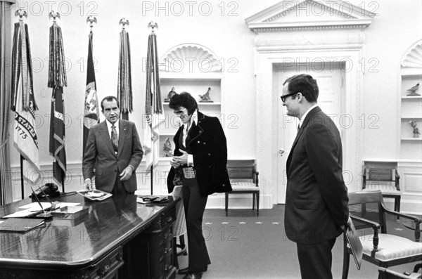 U.S. President Richard Nixon meeting with Elvis Presley during open hour in the Oval Office with assistant Egil Krogh standing nearby, White House, Washington, D.C., USA, White House Photo Office, December 21, 1970