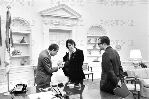 U.S. President Richard Nixon meeting with Elvis Presley during open hour in the Oval Office with assistant Egil Krogh standing nearby, White House, Washington, D.C., USA, White House Photo Office, December 21, 1970