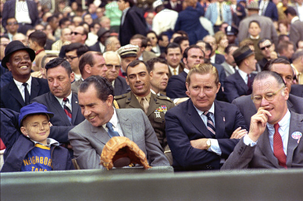 U.S. President Richard M. Nixon, enjoying opening day baseball with Washington Senators owner Bob Short (right of Nixon) and Baseball Commissioner Bowie Kuhn (far right with eyeglasses), Robert F. Kennedy Stadium, Washington, D.C., USA, White House Photo Office, April 7, 1969