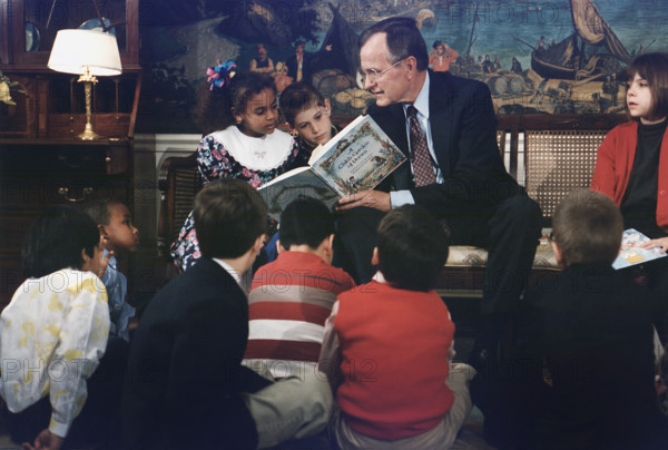 U.S. President George H.W. Bush reading a book to children during Great American Read Aloud Day, Diplomatic Reception Room, White House, Washington, D.C., USA, David Valdez, White House photographer, April 16, 1991