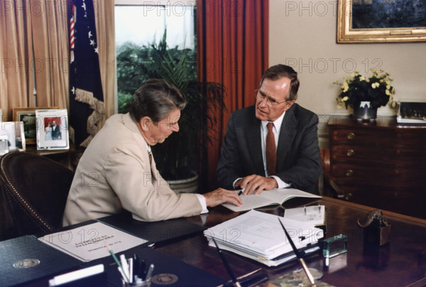 U.S. President Ronald Reagan and U.S. Vice President George H.W. Bush working in the Oval Office, White House, Washington, D.C., USA, David Valdez, White House photographer, July 20, 1984