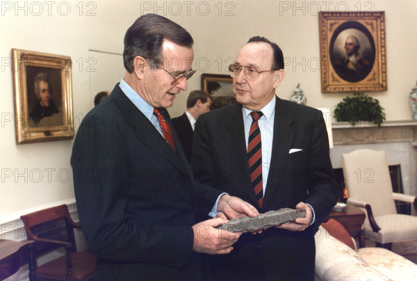 U.S. President George H.W. Bush is presented with a piece of the Berlin Wall by West German Foreign Minister Hans-Dietrich Genscher in the Oval Office, White House, Washington, D.C., USA, Susan Biddle, White House photographer, November 21, 1989