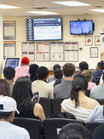 Group of people sitting in waiting area of U.S. Social Security Administration Office, New York City
