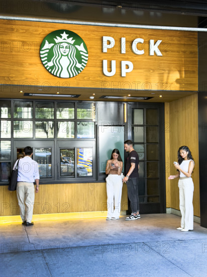 Customers waiting for their orders at service window, Starbuck's Pick Up, New York City