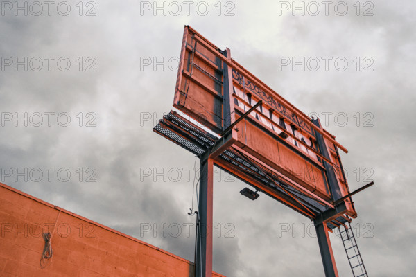 Low angle rear view of weathered billboard at dusk