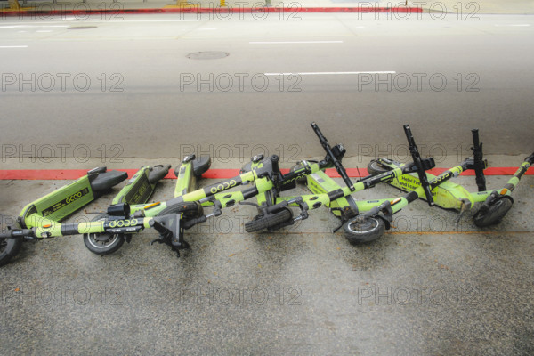 Row of fallen electric rental scooters on sidewalk, Los Angeles