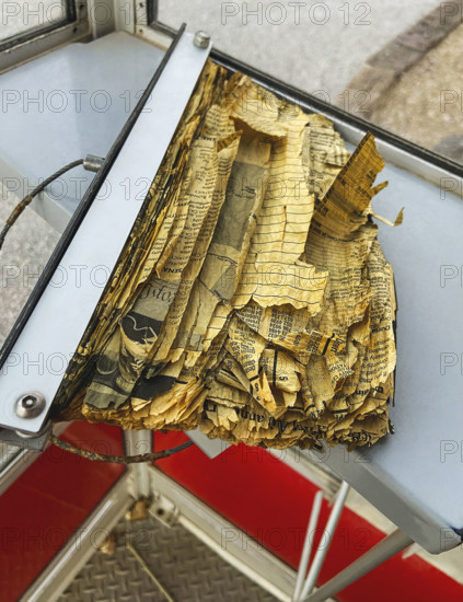 Tattered and torn phone book inside old telephone booth