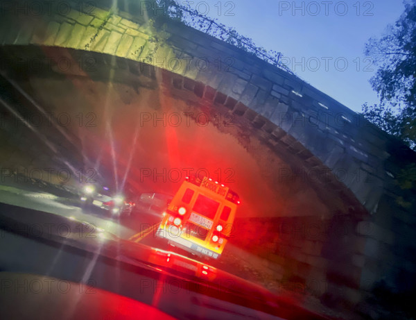 View from car of public school bus as it enters stone bridge tunnel at dusk