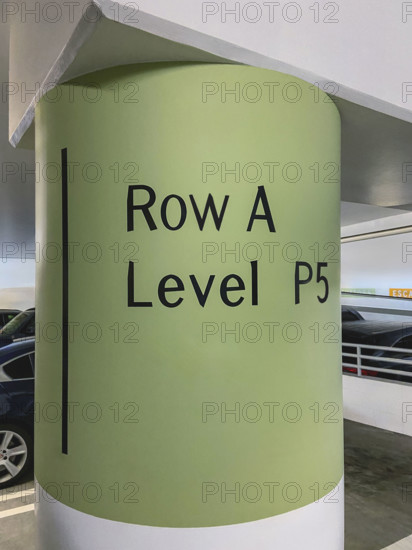 Painted cement column in public parking garage informing customers of their parking location