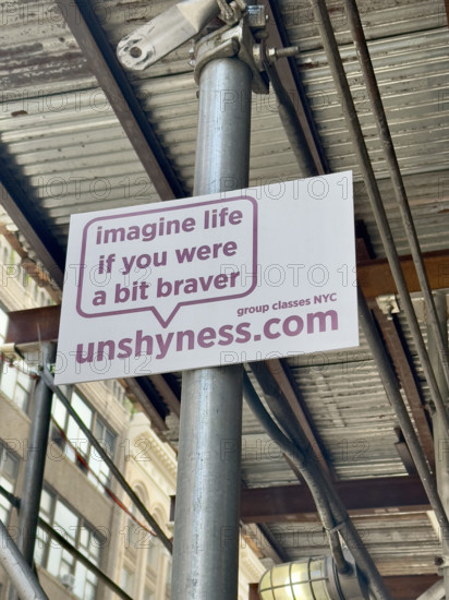 Advertising placard attached to building scaffold, New York City