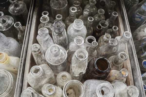 Assorted collection of old glass bottles for sale at roadside antique shop