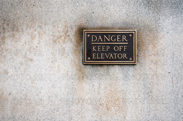 Bronze warning sign mounted on office building
