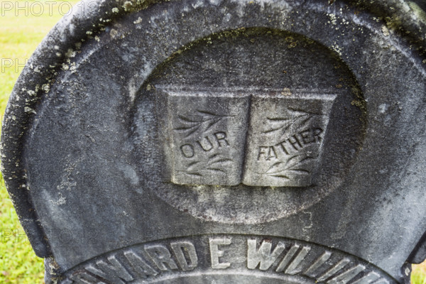 Weathered headstone featuring the words "Our Father"