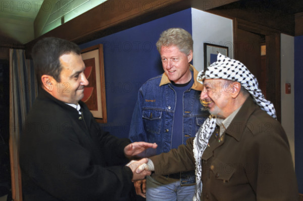 Israeli Prime Minister Ehud Barak and Palestinian Authority Chairman Yasser Arafat shaking hands as U.S. President Bill Clinton looks on during Jewish Shabbat dinner at Camp David during the Israeli/Palestinian Summit, Camp David, Maryland, USA, David Scull, White House Photographer, July 14, 2000