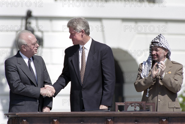 U.S. President Bill Clinton shaking hands with Israeli Prime Minister Yitzhak Rabin as Palestine Liberation Organization Chairman Yasser Arafat applauds during ceremony for Middle East Peace agreement signing, South Lawn of White House, Washington, D.C., USA, Vince Musi, White House Photographer, September 13, 1993