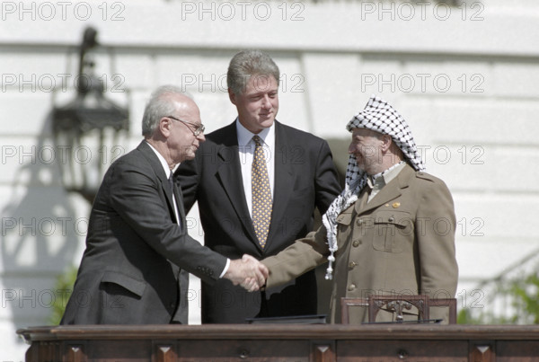 U.S. President Bill Clinton watching handshake between Israeli Prime Minister Yitzhak Rabin and Palestine Liberation Organization Chairman Yasser Arafat during ceremony for Middle East Peace agreement signing, South Lawn of White House, Washington, D.C., USA, Vince Musi, White House Photographer, September 13, 1993