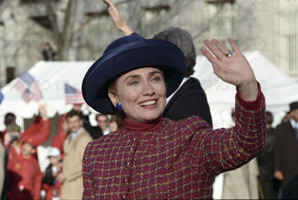U.S. First Lady Hillary Rodham Clinton  and U.S. President Bill Clinton (partially hidden) walking along the Inaugural Parade route and waving to the crowd, Washington, D.C., USA, Bob McNeely, White House Photographer, January 20, 1993