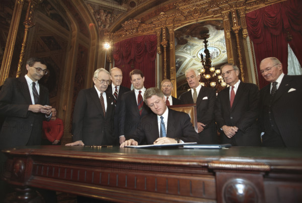 U.S. President Bill Clinton, joined by U.S. Vice President Al Gore and members of the Joint Congressional Committee on Inaugural Ceremonies, signing his first official documents as the newly sworn-in U.S. President, President's Room, U.S. Capitol, Washington, D.C., USA, Bob McNeely, White House Photographer, January 20, 1993