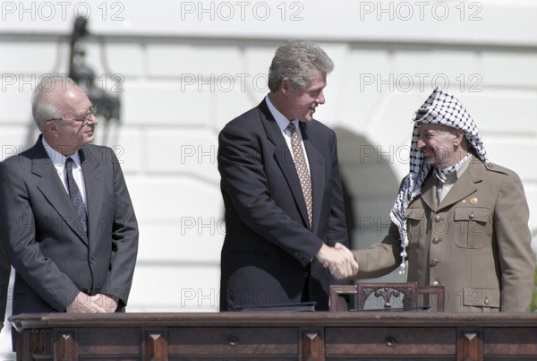 U.S. President Bill Clinton shaking hands with Palestine Liberation Organization Chairman Yasser Arafat as Israeli Prime Minister Yitzhak Rabin looks on during ceremony for Middle East Peace agreement signing, South Lawn of White House, Washington, D.C., USA, Vince Musi, White House Photographer, September 13, 1993