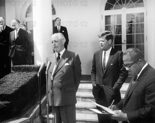 British Prime Minister of Great Britain Harold Macmillan prepares to speak as U.S. President John F. Kennedy looks on during a reading of the President and Prime Minister’s joint statement in the Rose Garden, White House, Washington, D.C. Washington, D.C., USA, Abbie Rowe, White House Photographs, April 8, 1961