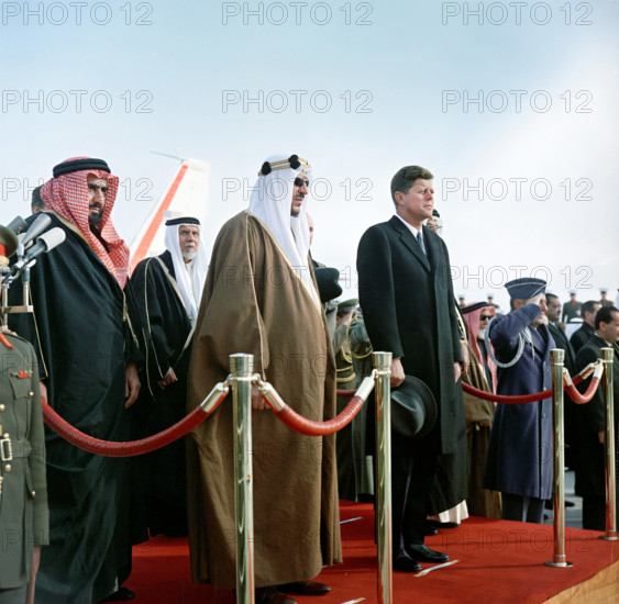 King of Saudi Arabia Saud bin Abdul-Aziz Al Saud (center) and U.S. President John F. Kennedy (right) stand on reviewing platform at Andrews Air Force Base, Prince George's County, Maryland., USA, Robert Knudsen, White House Photographs, February 13, 1962