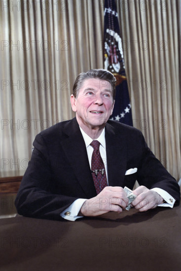U.S. President Ronald Reagan's address to the nation on the economy (holding dollar) from Oval Office of the White House, Washington, D.C., USA, President Ronald Reagan White House Photographic Office, February 5, 1981