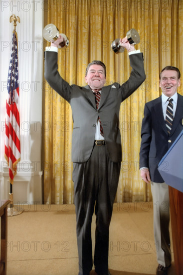 U.S. President, Ronald Reagan lifting weights with George Allen looking on during White House reception for President's Council on Physical Fitness and Sports, White House, Washington, D.C., USA, President Ronald Reagan White House Photographic Office, February 2, 1982